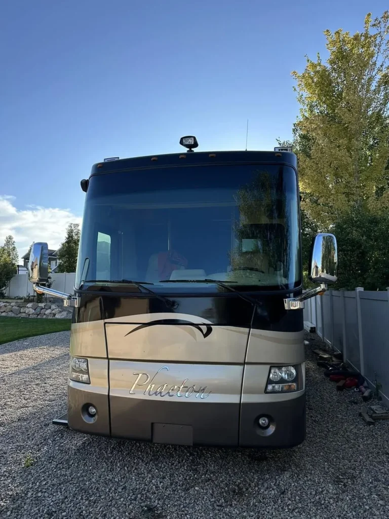 Front of a Class A motorhome on a job site before windshield service