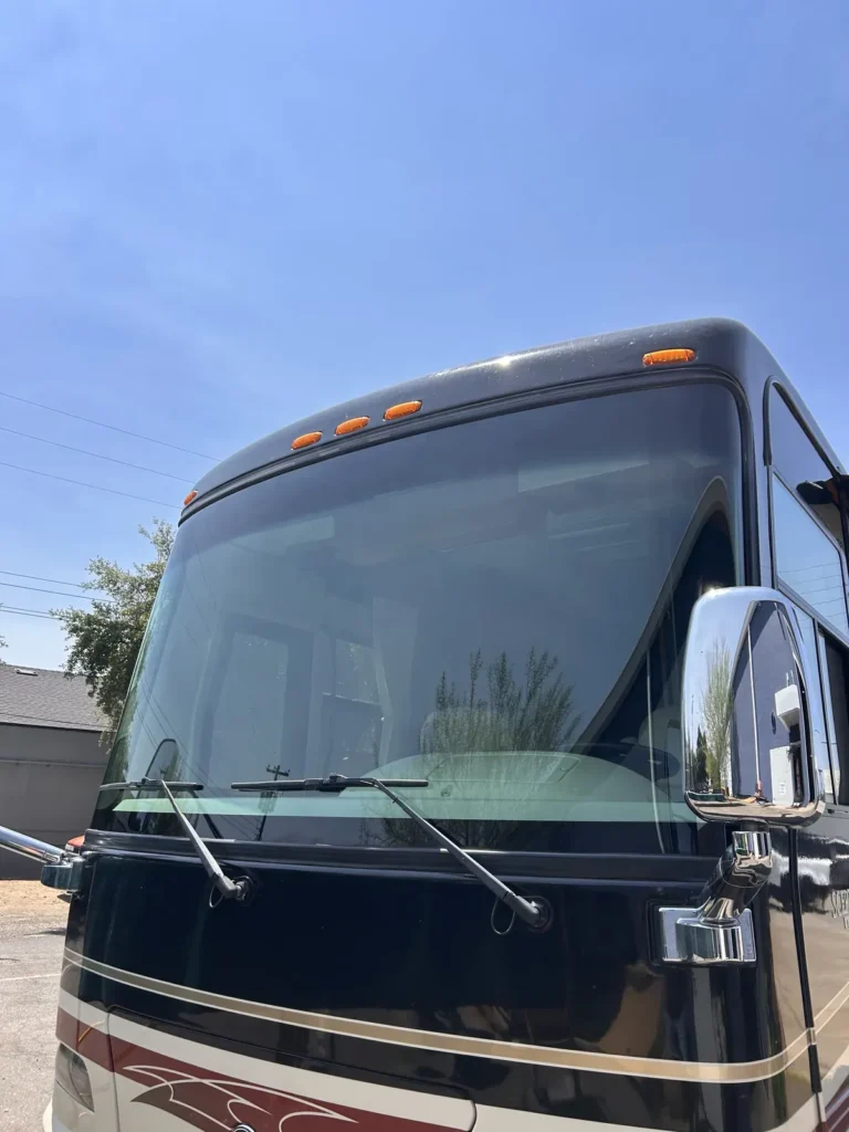 Front of a motorhome showing its large RV windshield and wipers