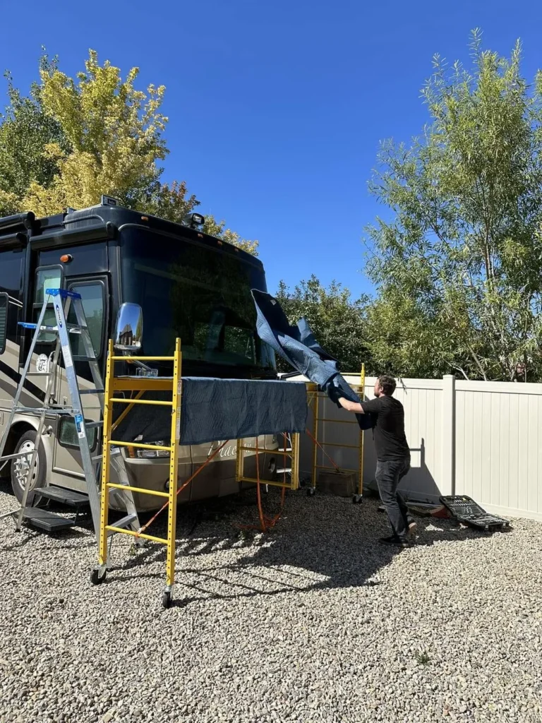 RV windshield replacement on a Class A motorhome, worked from scaffolding