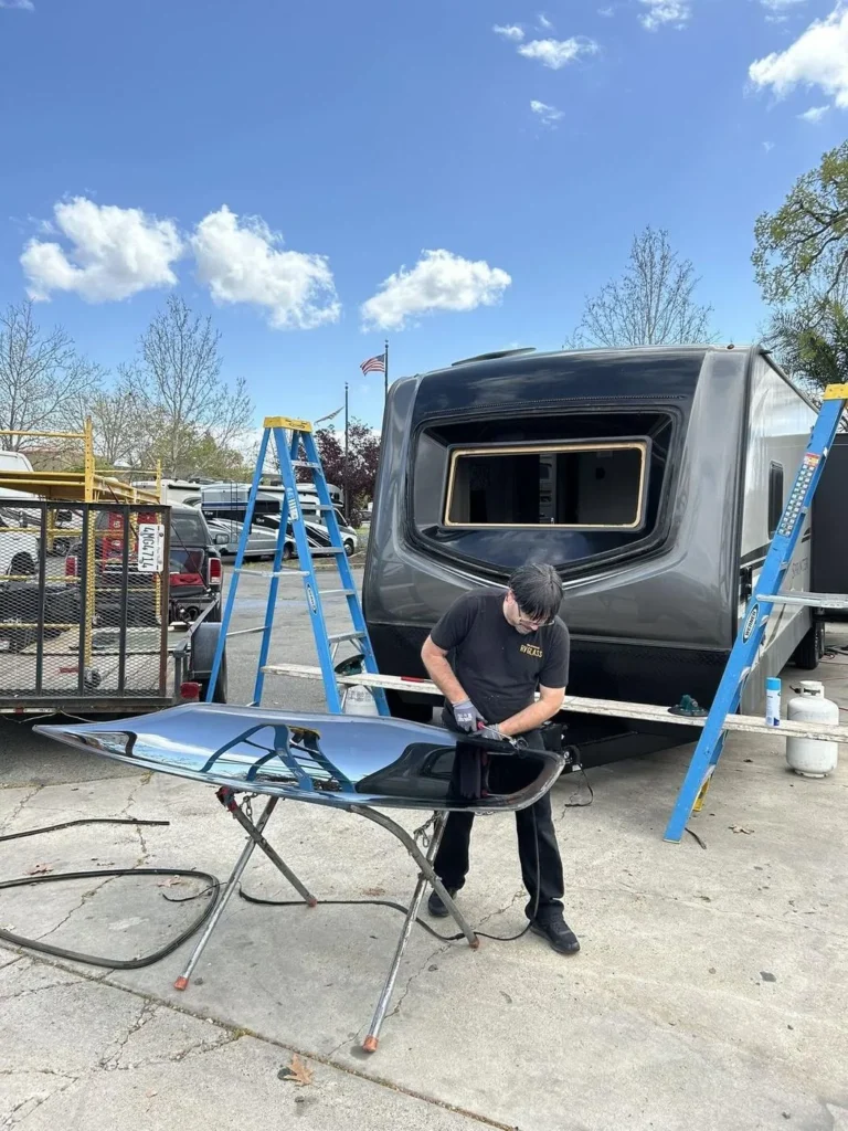 Technician prepping replacement glass for a travel trailer front window
